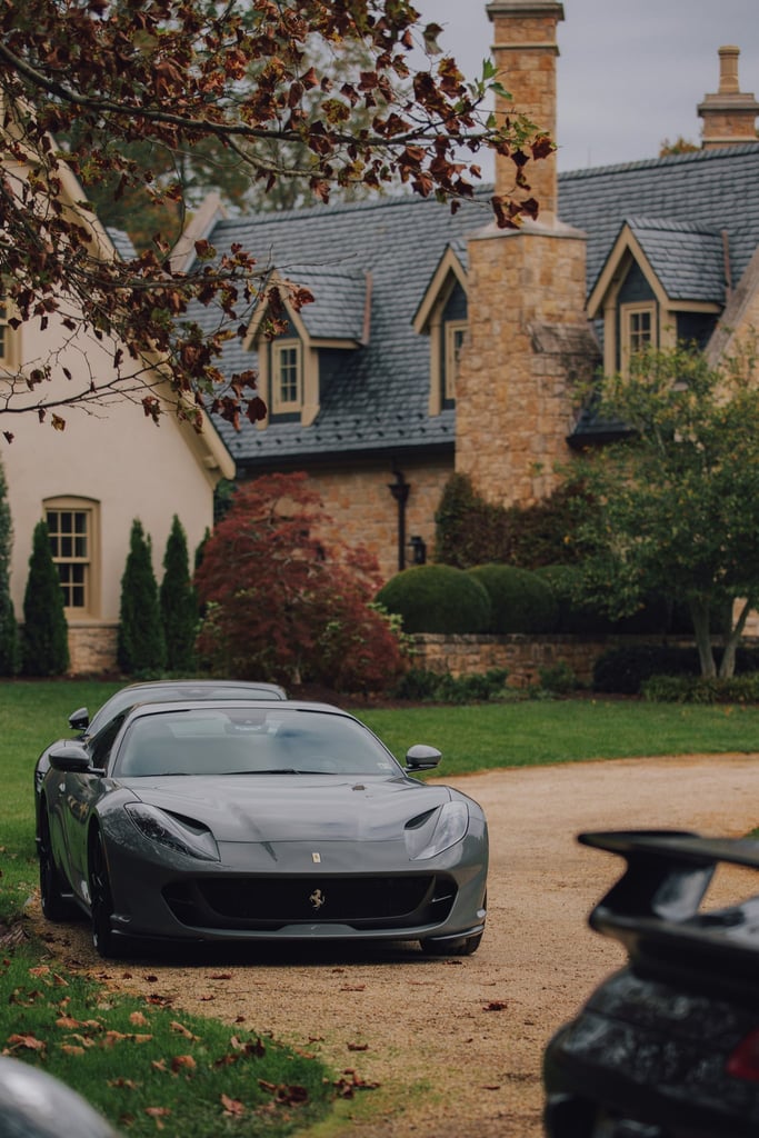Ferrari 812 Superfast at the Estate parked on a gravel driveway with classic stone house in the background, ideal car wall art.