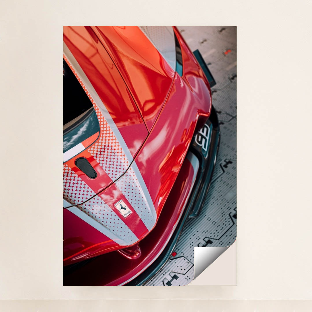 This photo shows a close-up view of a red Ferrari with dotted racing stripes reflecting dramatic skies, minimalist unframed style.