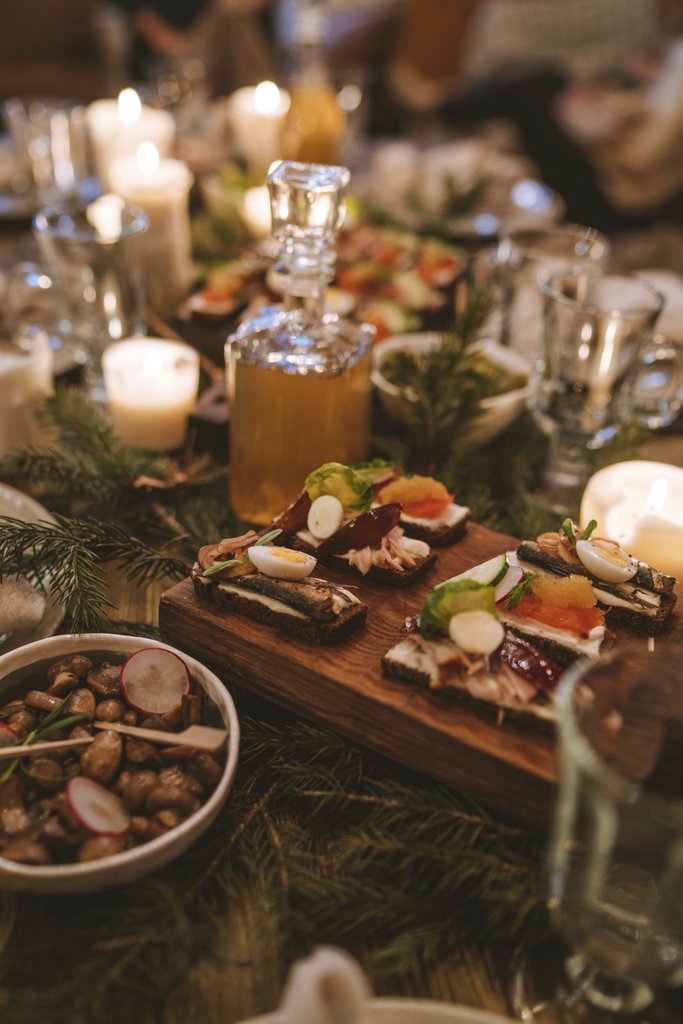 Anastasia  Shuraeva - Cozy holiday dinner scene with candles, appetizers, and festive decor.