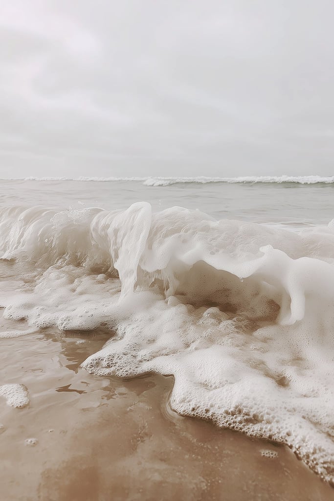 Foamy Ocean Wave Crashing onto Sandy Shore under Overcast Sky by Mistline