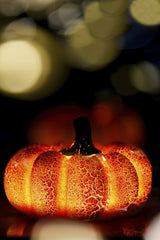 Denys Gromov - A vibrant glass pumpkin illuminated against a backdrop of glowing bokeh lights, perfect for fall themes.