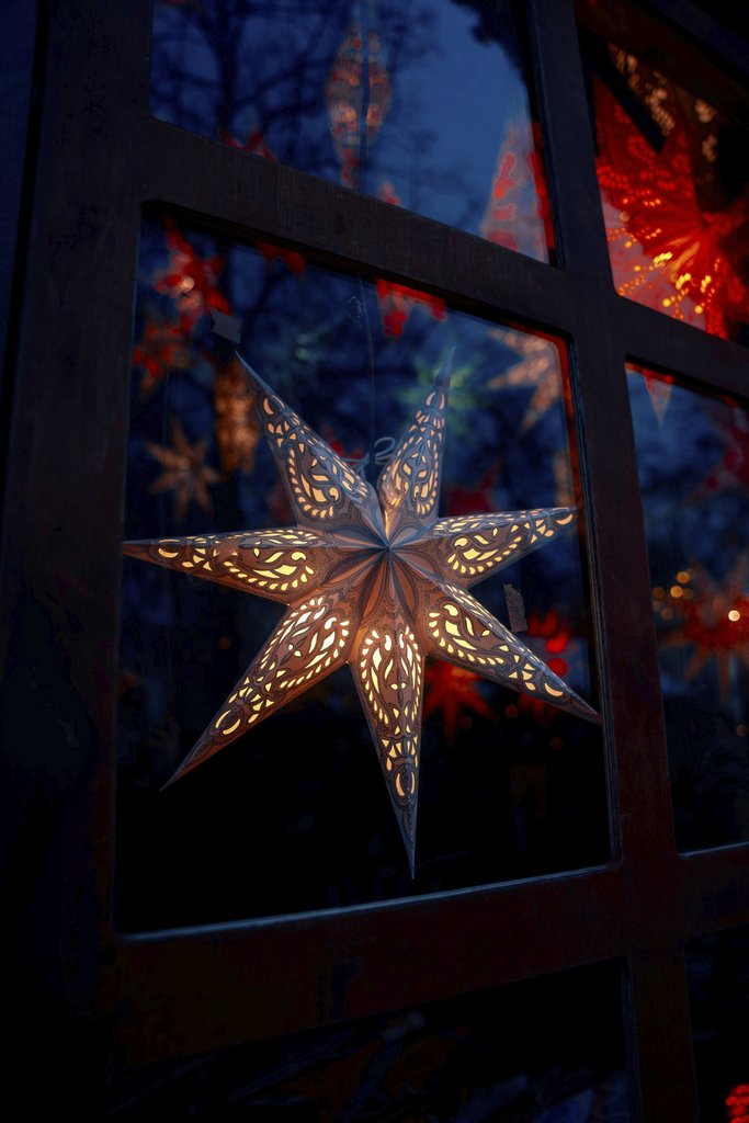 Christiyana - Illuminated star lantern glowing warmly at a festive Berlin Christmas market at night.