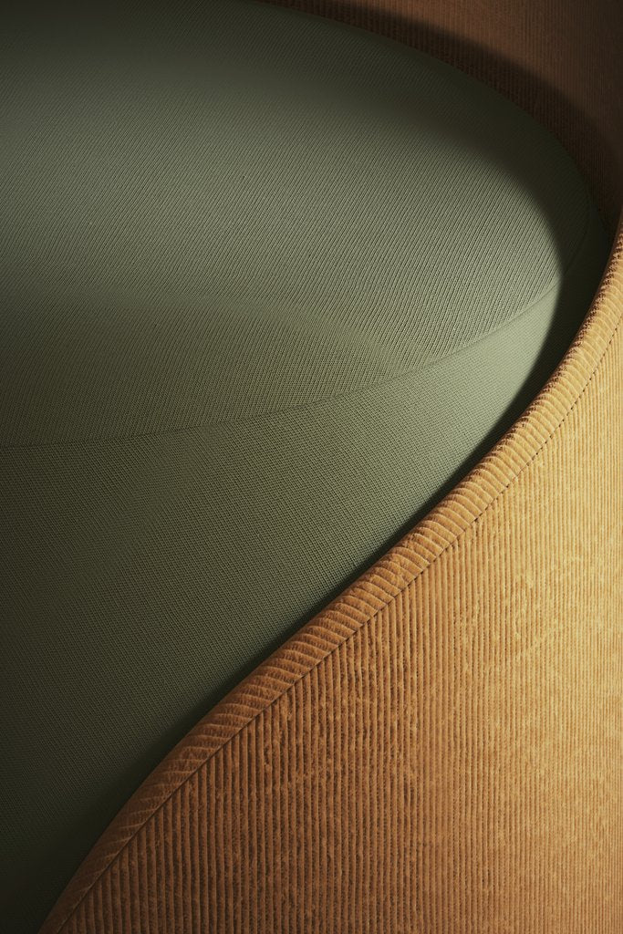 Bilal Mansuri - Close-up of a modern armchair showcasing its textured fabric and sleek design.