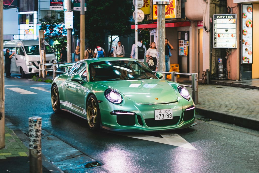 Porsche 911 Turbo S exploring Taipei's Streets, vibrant green car navigating urban nightlife, perfect for car wall art.
