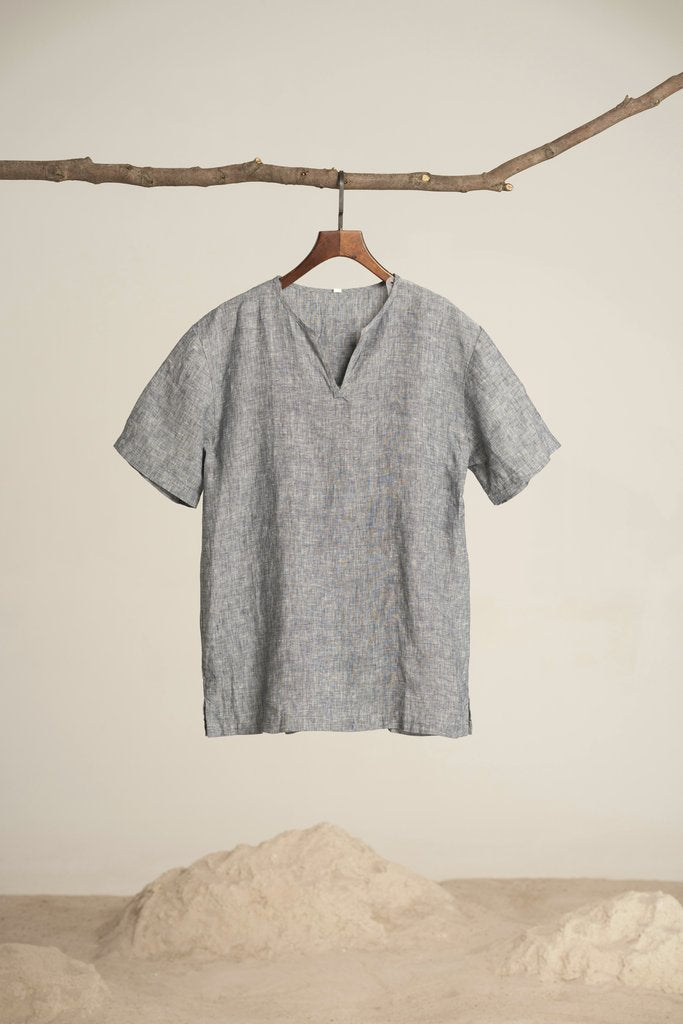 dayong tien - A grey t-shirt hangs on a branch against a textured background, capturing minimalist fashion.
