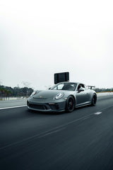 Grey Porsche 911 GT3 in Motion, racing on highway with matte grey finish and sleek design, perfect car wall art.