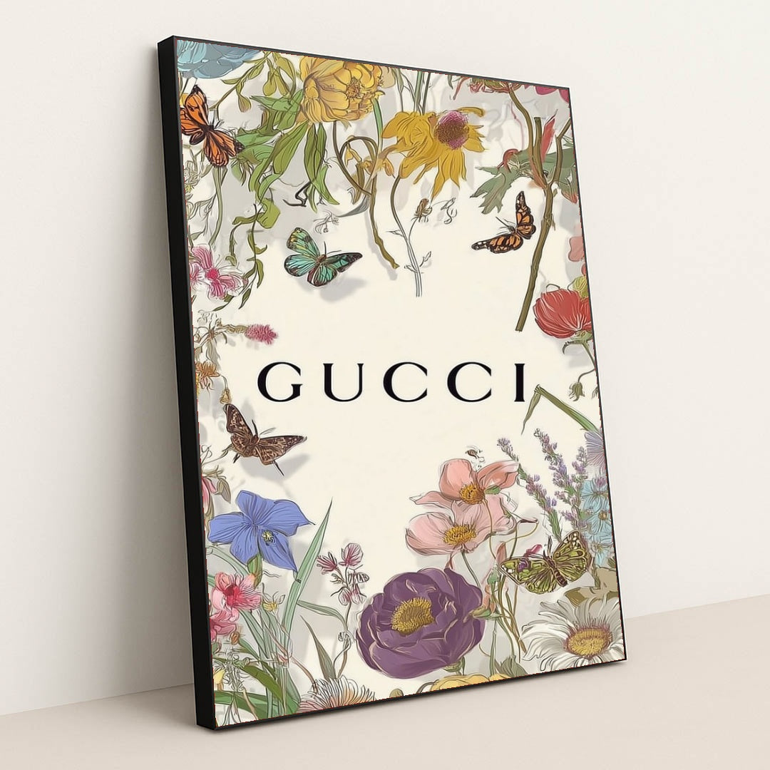 This artwork shows a floral Gucci design with colorful wildflowers, butterflies, and the Gucci logo on a pale background, in a black frame.