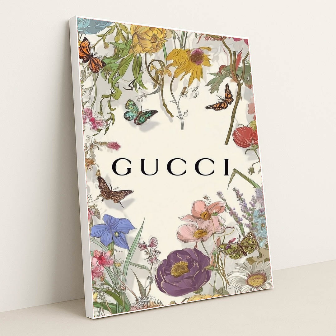 This artwork shows a floral Gucci design with colorful wildflowers, butterflies, and the Gucci logo on a pale background, in a white frame.