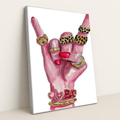 This artwork shows a hand with pink nails making a rock gesture, adorned with gold and animal print rings, and heart bracelets, in a silver frame.