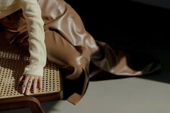cottonbro studio - A close-up of an elegant hand adorned with silver rings on a cane chair with satin fabric.