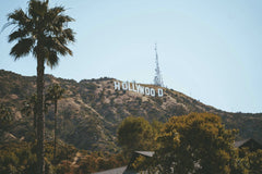 Alex Barnes - A scenic view of the Hollywood Sign surrounded by hills and palm trees in Los Angeles, California.