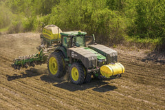 Mark Stebnicki - A tractor sowing seeds in a rural field on a sunny day in Prospect, NC.