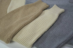 Ron Lach - Flat lay of cozy knit sweaters in beige and gray tones. Perfect for winter fashion.