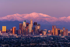 Stock Photos - Downtown Los Angeles skyline with snow capped mountains behind at twilight