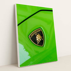 This photo shows a close-up of a Lamborghini badge on a bright green car, in a white frame.