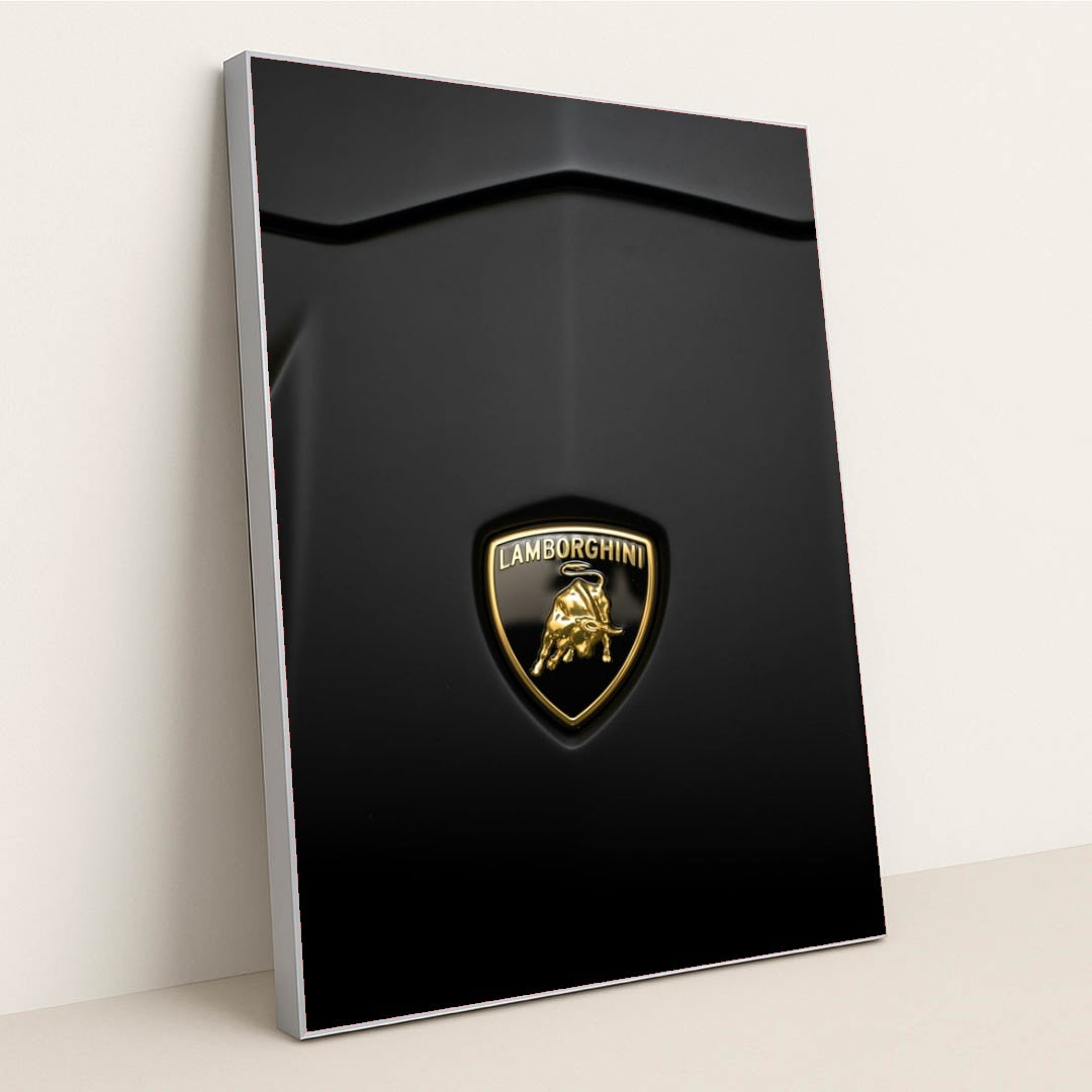 This photo shows a close-up of a Lamborghini badge on a matte black car hood, in a silver frame.