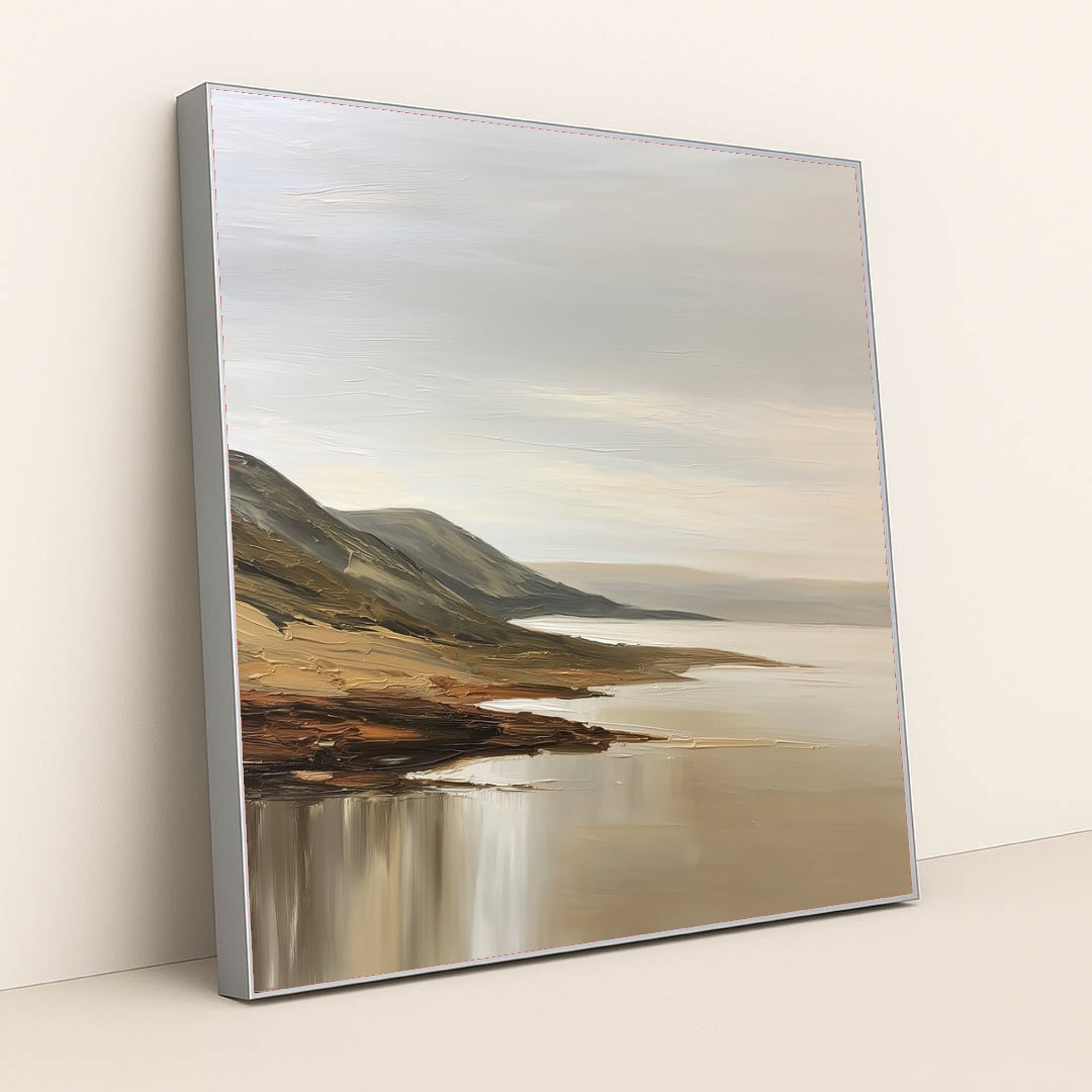 This artwork features a tranquil coastal landscape with rolling hills and calm waters painted in soft neutral tones, displayed in a silver frame.
