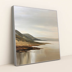 This artwork features a tranquil coastal landscape with rolling hills and calm waters painted in soft neutral tones, displayed in a silver frame.