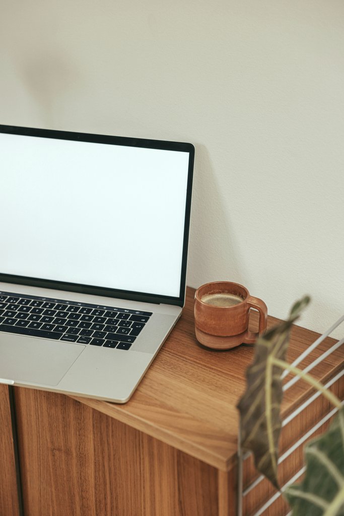 Cup of  Couple - A minimalist workspace setup featuring a laptop and coffee mug on a wooden desk.