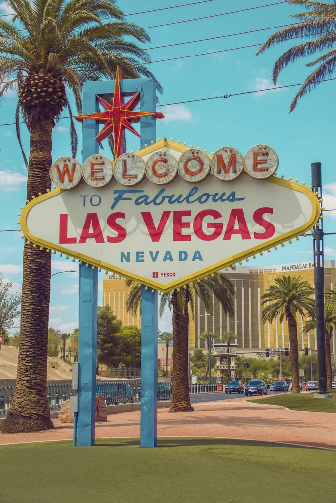 Dimitri Baret - Famous Welcome to Fabulous Las Vegas sign with palm trees under a blue sky.