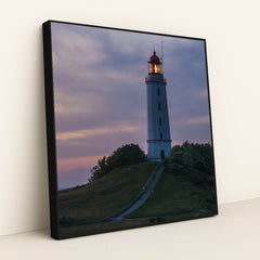 Illuminated Coastal Lighthouse on Hill During Evening Twilight by Karl Knips - Black Frame Stretchiez