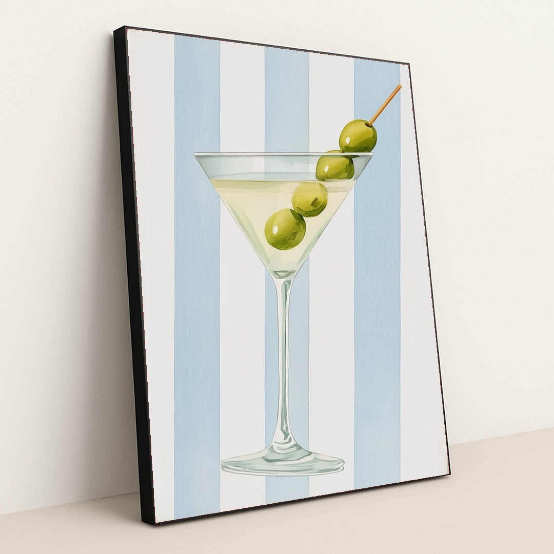 This artwork features a classic martini glass with three green olives against vertical blue and white stripes, in a black frame.