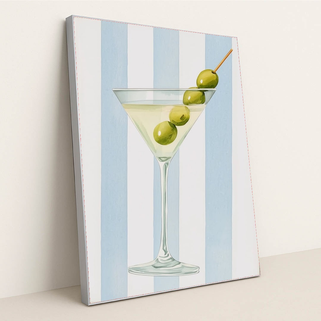 This artwork features a classic martini glass with three green olives against vertical blue and white stripes, in a silver frame.