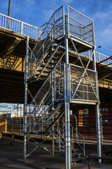 Victor  Moragriega - Dynamic urban scene featuring a sturdy metal staircase under an overpass.