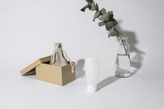 Cup of  Couple - A minimalist composition showcasing a box, cream container, and eucalyptus branch on a white background.