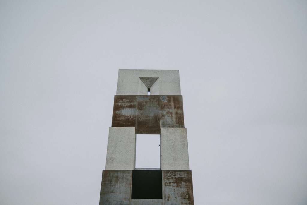 Emre  Akyol - Low angle view of a geometric concrete structure with a minimalistic design against a pale sky.