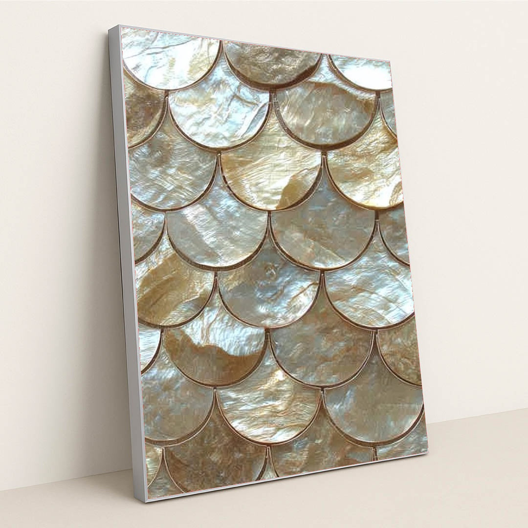 This artwork shows scalloped gold and pearl tiles in an overlapping scale pattern, in a silver frame.