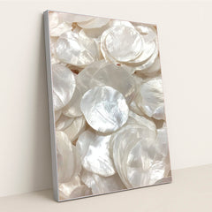 This artwork shows glossy, layered white capiz shells in soft light, in a silver frame.