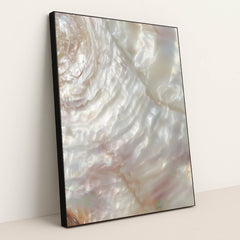 This artwork shows a close-up of iridescent mother-of-pearl shell with swirling light reflections, in a black frame.