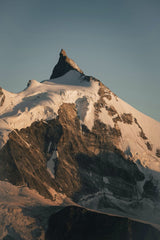 Damien Schnorhk - Stunning view of a snow-covered alpine peak in the Swiss Alps at sunrise.