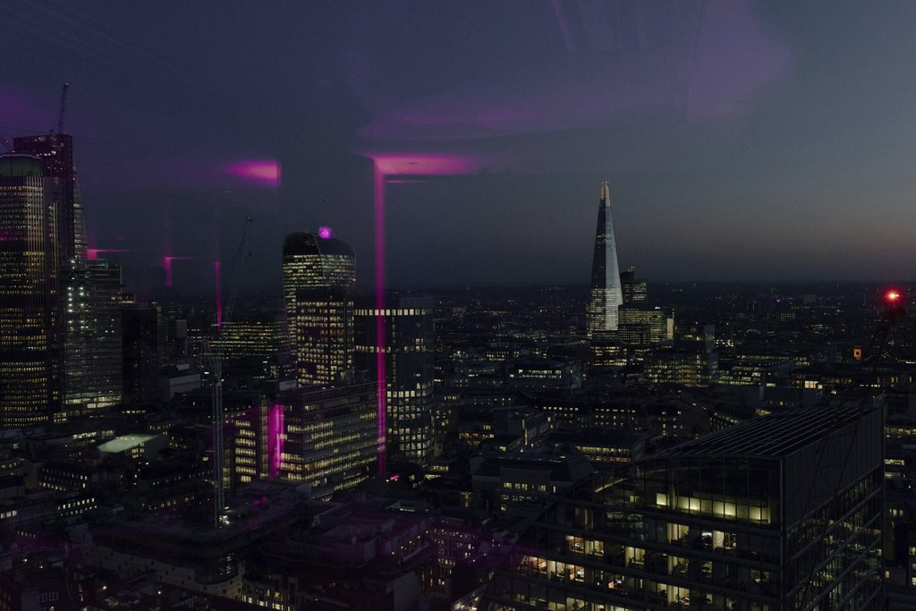 Olga Lioncat - Stunning view of the London skyline at night, featuring iconic skyscrapers and vibrant city lights.