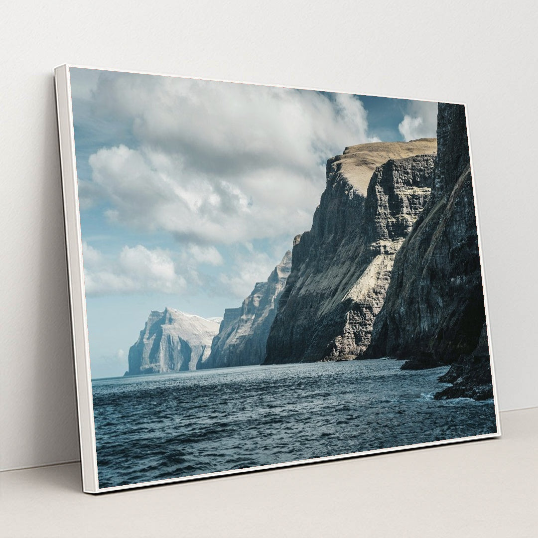 Majestic Ocean Cliffs Under Cloudy Sky by Raul Ling - White Frame Stretchiez