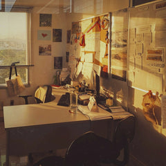 Leandro Queiroz - Contemporary office with desk and bulletin board in warm sunset lighting.