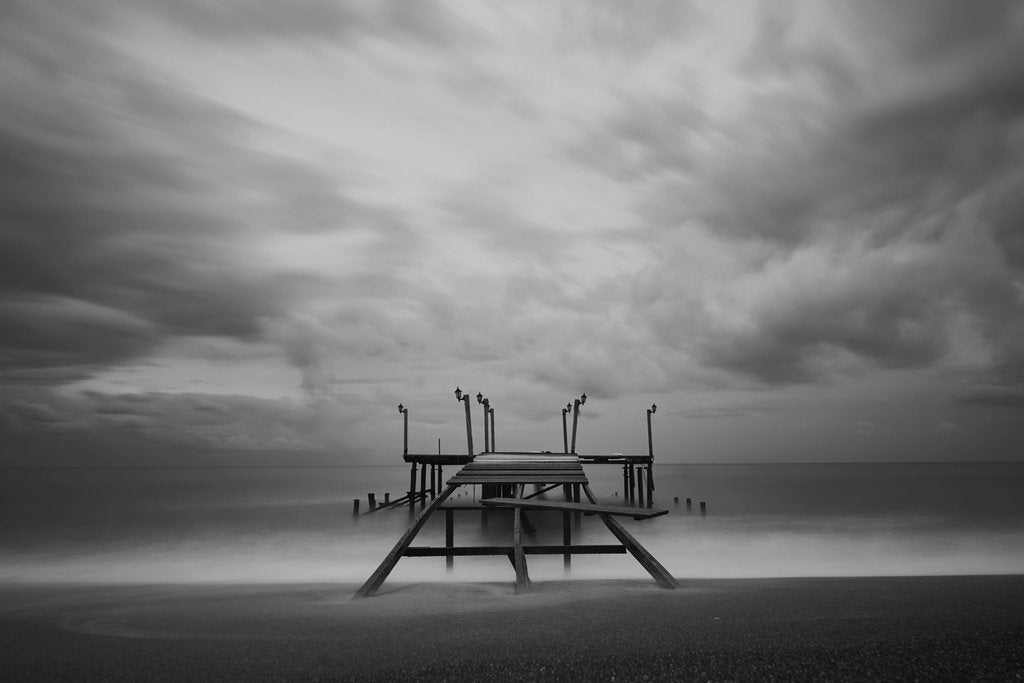 Engin Akyurt - A moody black and white seascape featuring a lonely pier under cloudy skies, evoking solitude.