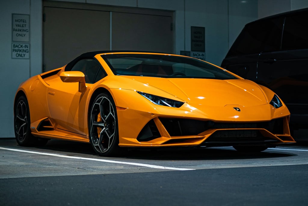 Vibrant orange Lamborghini Heat car wall art, showcasing its sleek design in a dimly lit parking garage.