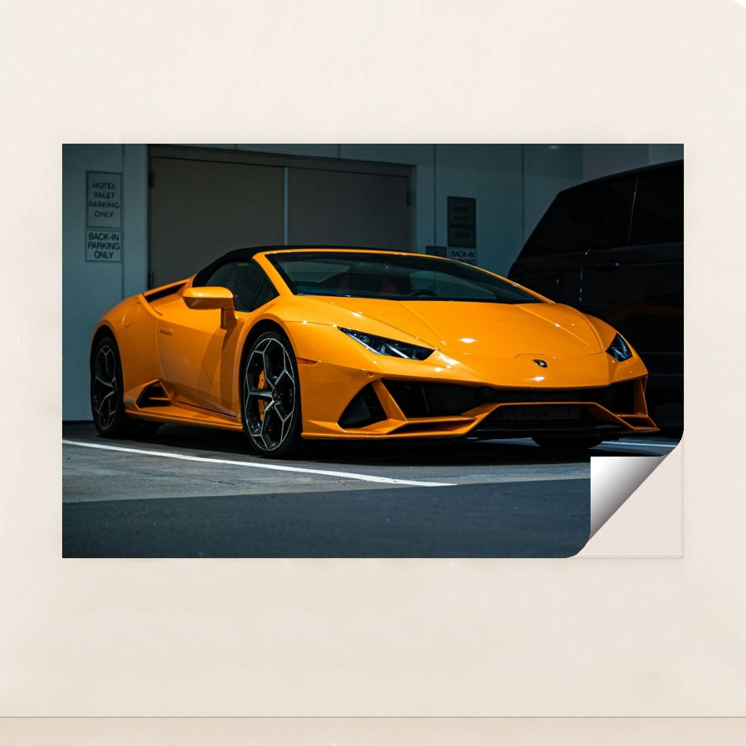 This photo shows an orange Lamborghini Huracán Spyder parked in a valet area at night, unframed.