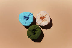 Edward Jenner - Vibrant blue, green, and peach toilet paper rolls on a peach background.