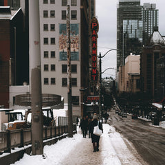 Qingju Wen - Snow-covered street scene in Seattle featuring the Paramount Theater and pedestrians.