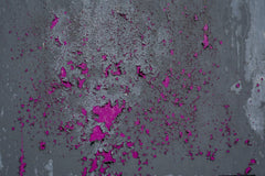 Victor  Moragriega - Close-up of a weathered wall with peeling pink paint creating an abstract pattern.