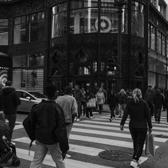 Qiang Lai - A bustling city street scene with people crossing at a crosswalk in an urban environment.