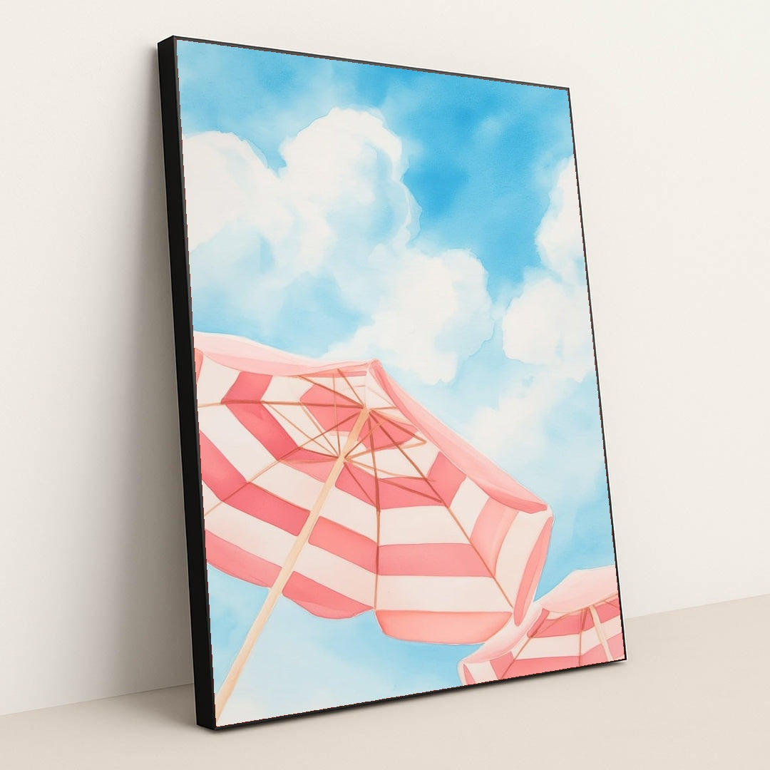 This artwork features pink and white striped beach umbrellas against a blue sky with clouds, in a black frame.