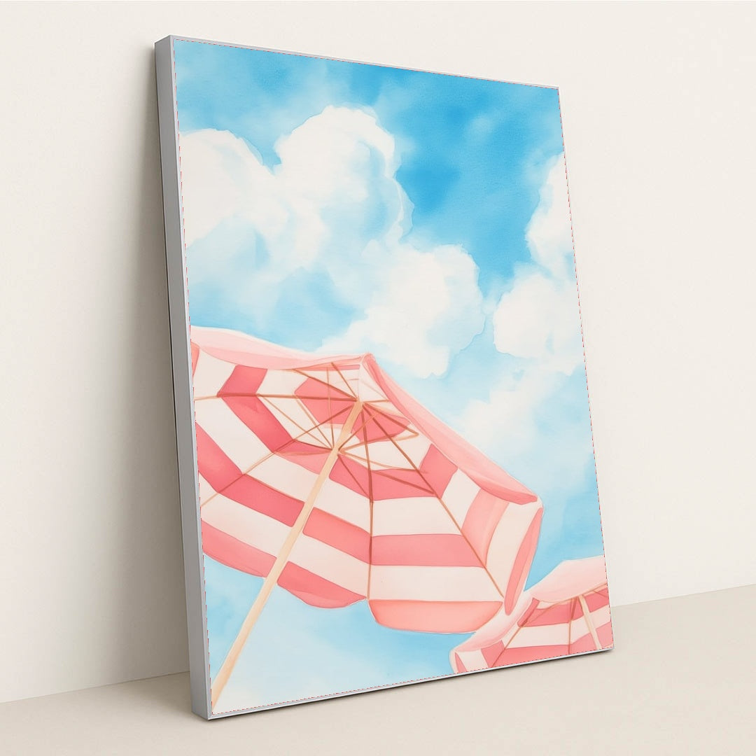 This artwork features pink and white striped beach umbrellas against a blue sky with clouds, in a silver frame.