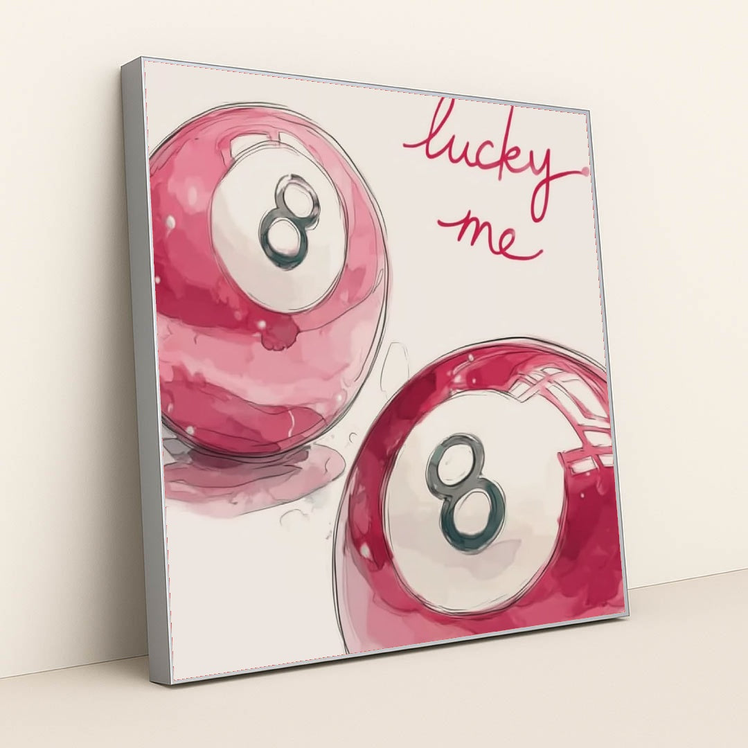This artwork shows two pink magic eight balls with the words "lucky me" written in bright script above, in a silver frame.