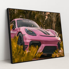 This photo shows a pink Porsche sports car with black stripes parked near tropical palm trees, in a black frame.