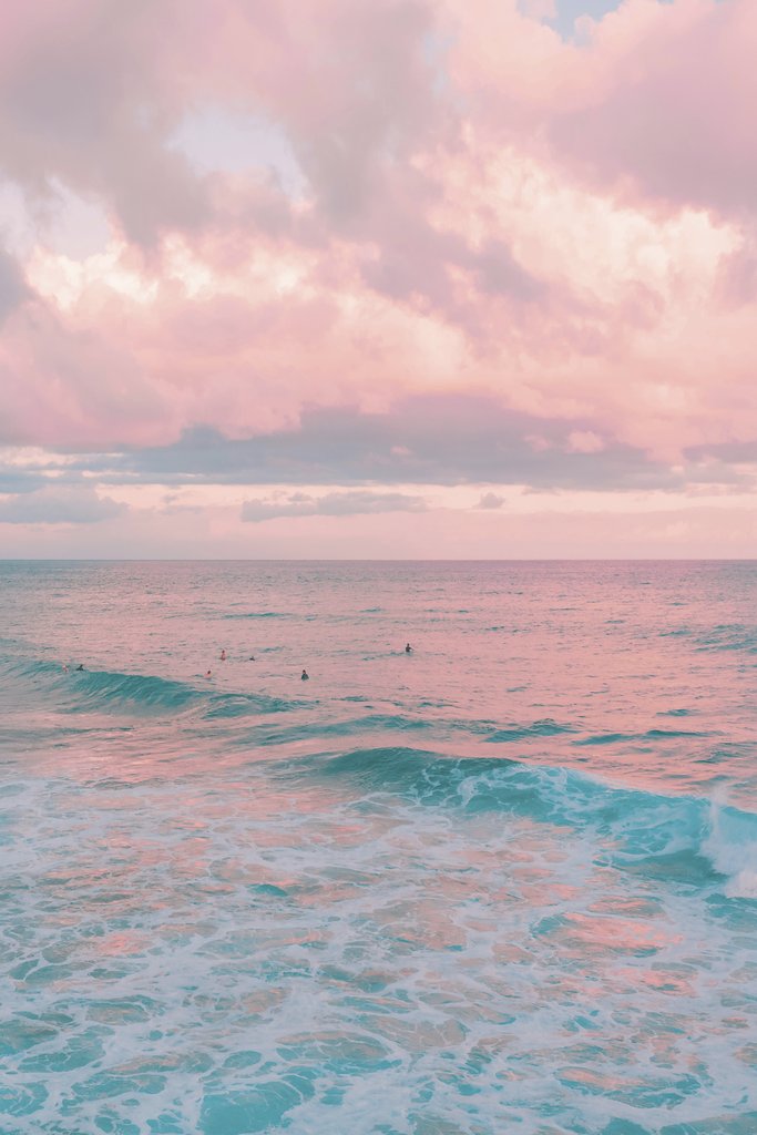 Pink Clouds at Dusk Above Ocean Waves with Surfers by Jess Loiterton