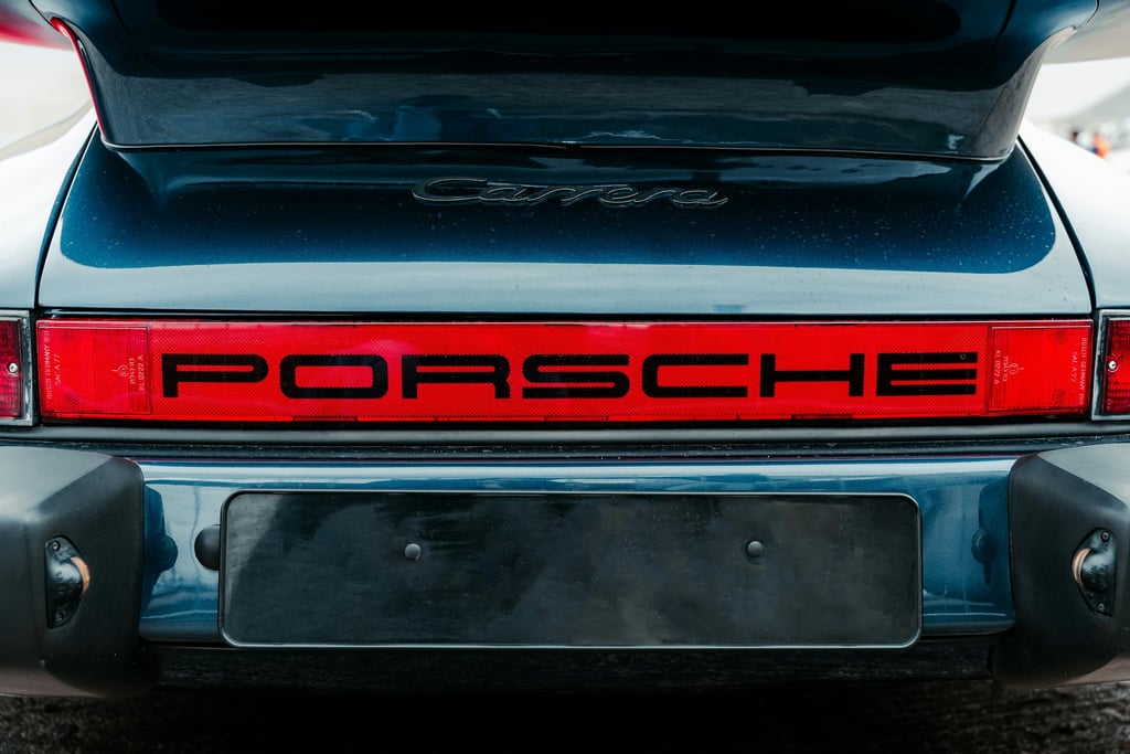 Porsche Carrera Rear in Focus showcasing red light bar and taillights, vintage car wall art in metallic blue.